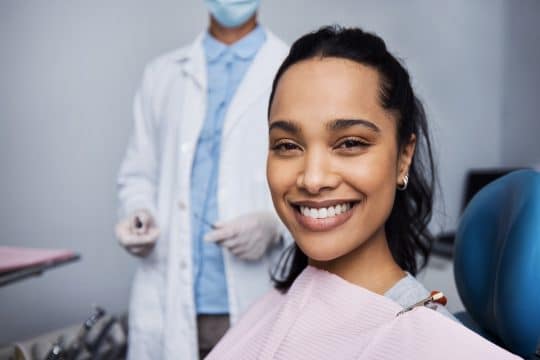 Woman smiling from the dentist seat with a bright smile