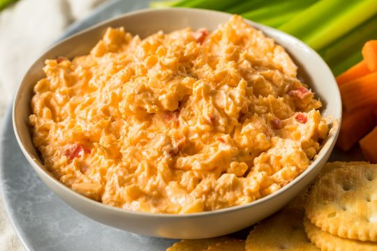 Pimento Cheese in a bowl next to veggie sticks and ritz crackers