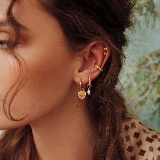 Woman with earrings and a gold ear cuff