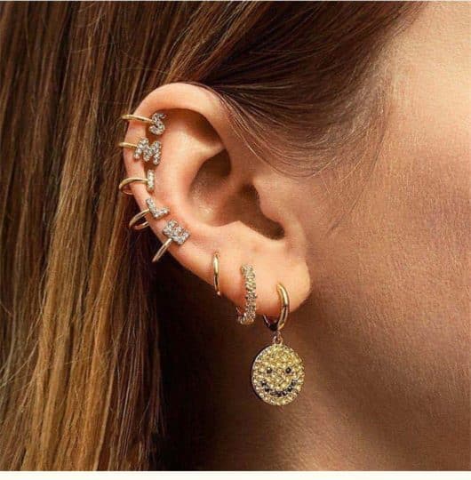 Woman with the word SMILE spelled out in ear cuffs
